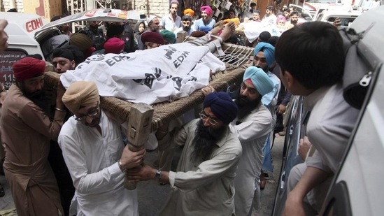 Pakistani Sikhs carry the body of a Sikh who was killed by gunmen in Peshawar, Pakistan, Sunday. (AP)