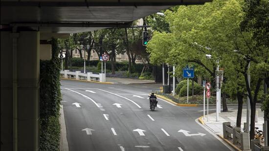 A delivery worker rides a motorcycle rides along a near-empty road during a lockdown due to Covid-19 in Shanghai, China, on Monday. (Bloomberg) A delivery worker rides a motorcycle rides along a near-empty road during a lockdown due to Covid-19 in Shanghai, China, on Monday. (Bloomberg)
