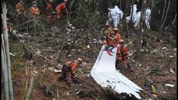 Trabalhadores realizam buscas pela caixa preta perto dos destroços no local do acidente do voo da China Eastern no condado de Tengxian, na região autônoma de Guangxi Zhuang, no sul da China, em 24 de março de 2022. (AP)