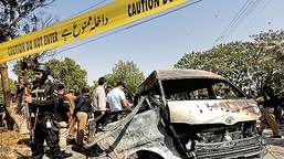 Policiais e unidade de cena do crime se reúnem perto de uma van de passageiros, após explosão na entrada do Instituto Confúcio, Universidade de Karachi, Paquistão 26 de abril de 2022 (REUTERS)