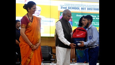 Chandigarh administrator Banwarilal Purohit distributing the books and with stationery among government school students. (Ravi Kumar/HT)