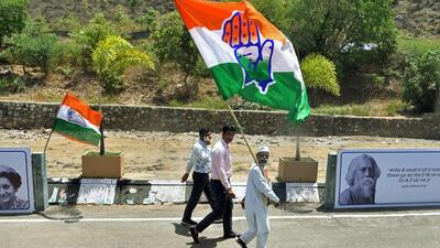 A Congress supporter holds the party flag on the concluding day of the party's Nav Sankalp Chintan Shivir, in Udaipur on Sunday (ANI)