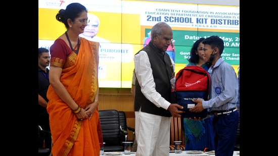 Chandigarh administrator Banwarilal Purohit distributing the books and with stationery among government school students. (Ravi Kumar/HT)