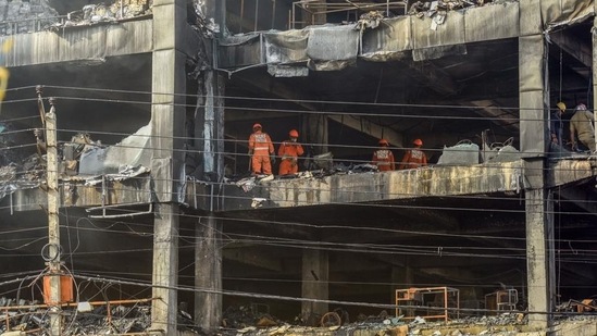 NDRF personnel clear the charred debris from a burnt floor a day after a fire broke out in a commercial building at Mundka, New Delhi. (HT PHOTO.)
