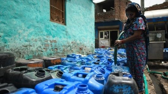 People fill their containers from Delhi Jal Board's water tankers in New Delhi on Tuesday, May 17, 2022, due to a severe supply disruption amid scorching heat.(Sanchit Khanna/HT)