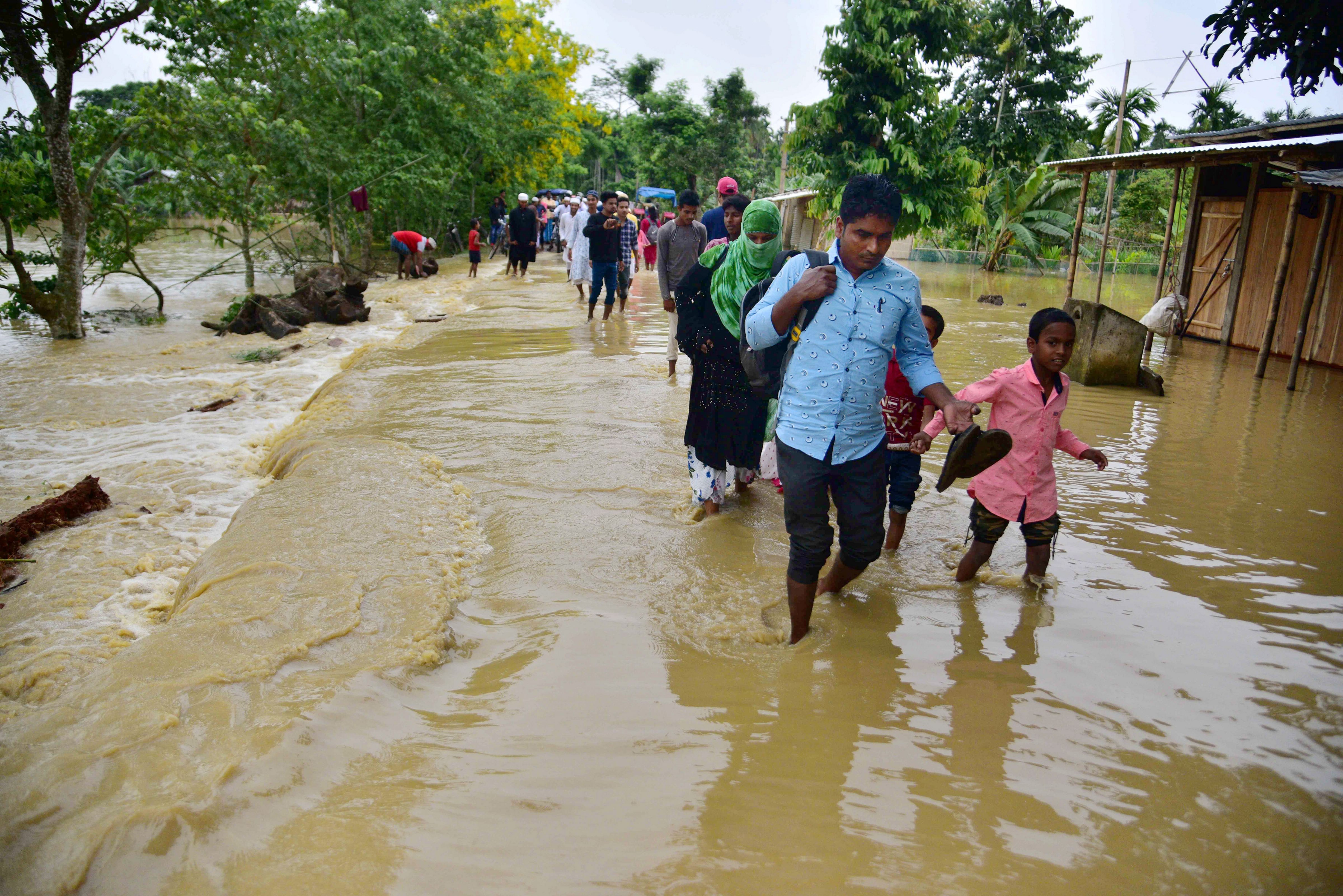 Hojai: Villagers wade through a flood affected area following heavy rains in Hojai district of Assam. (PTI) Hojai: Villagers wade through a flood affected area following heavy rains in Hojai district of Assam. (PTI)