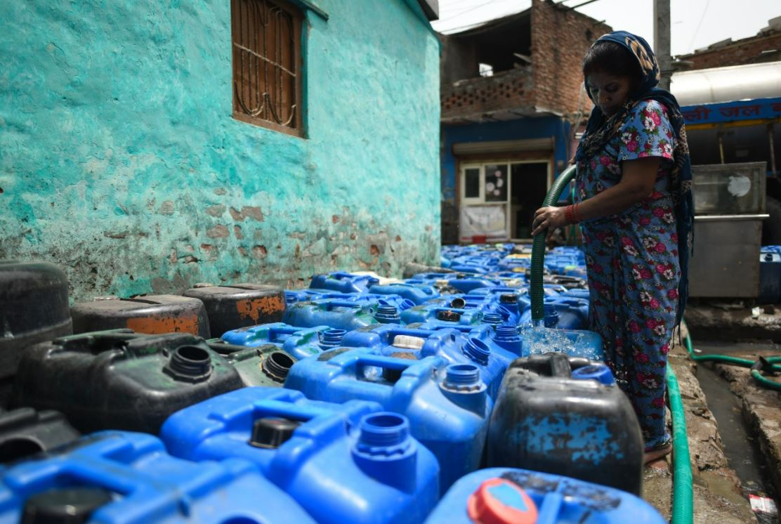 People fill their containers from Delhi Jal Board's water tankers in New Delhi on Tuesday, May 17, 2022, due to a severe supply disruption amid scorching heat.(Sanchit Khanna/HT)