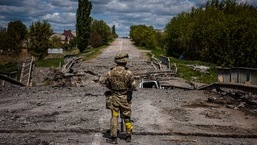 Um soldado da unidade de forças especiais ucranianas Kraken observa a área em uma ponte destruída na estrada perto da vila de Rus'ka Lozova, ao norte de Kharkiv.
