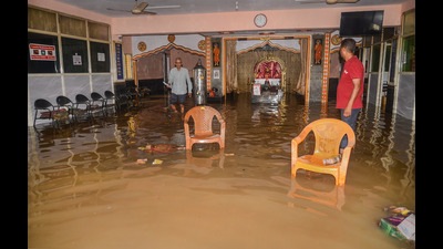 Residents enter a waterlogged temple after heavy overnight rain, at the Horamavu area in Bengaluru on Wednesday. (PTI) Residents enter a waterlogged temple after heavy overnight rain, at the Horamavu area in Bengaluru on Wednesday. (PTI)