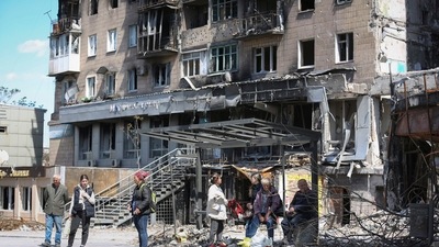 Local residents stand at a bus stop in Mariupol, in territory under the government of the Donetsk People's Republic, eastern Ukraine. (AP)