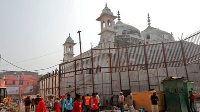 Labourers work in the compound of a temple next to the wall fence of Gyanvapi Mosque. (REUTERS)