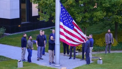 Employees of US embassy in Ukraine raise the US national flag at the US embassy, as Russia's attack on Ukraine continues, in Kyiv, Ukraine. (AP)