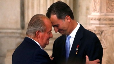 Spain's King Juan Carlos and his son Crown Prince Felipe (R) hug each other as they attend the signature ceremony of the act of abdication at the Royal Palace in Madrid. (REUTERS)