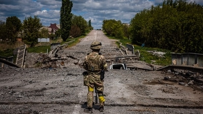 A soldier of the Kraken Ukrainian special forces unit observes the area at a destroyed bridge on the road near the village of Rus'ka Lozova, north of Kharkiv. (AFP) A soldier of the Kraken Ukrainian special forces unit observes the area at a destroyed bridge on the road near the village of Rus'ka Lozova, north of Kharkiv. (AFP)