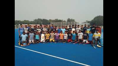 Meghbaran Singh Hockey stadium trainees pose with chief coach Indradev (centre) in Karampur. (HT Photo)