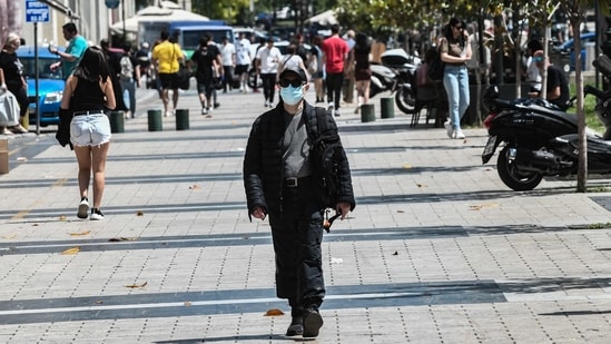 A pedestrian walks in the street wearing protective face mask in the center of Thessaloniki, northern Greece.(AFP)