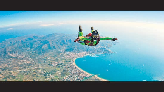 Sea skydive background. Man jumps with parashute (Shutterstock)