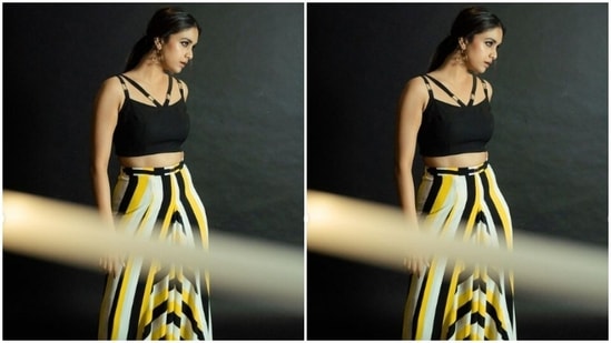 Keerthy decked up in a black cropped top with slip-in sleeves and a strap on the shoulders. She paired it with a long flowy skirt that came in stripes of yellow, black and white.(Instagram/@keerthysureshofficial)
