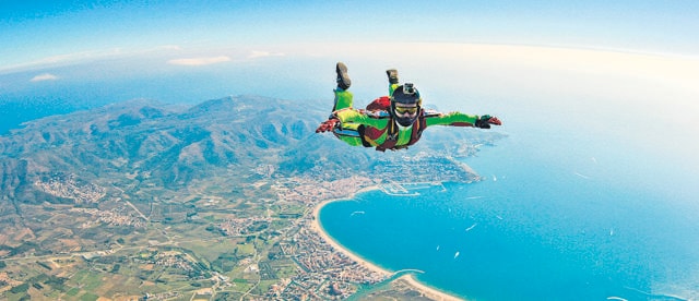 Sea skydive background. Man jumps with parashute (Shutterstock)