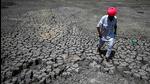 A man walks through the cracked bottom of a dried-out pond at Bandai village in Rajasthan’s Pali district on May 11. (AFP)
