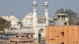 A worker stands on a temple rooftop adjacent to the Gyanvapi Mosque in the northern city of Varanasi, India, December 12, 2021. REUTERS/Pawan Kumar (REUTERS File Photo)