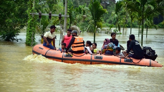 SDRF personnel evacuate villagers from flood affected area at a village in Nagaon District of Assamon Wednesday. (ANI Photo)