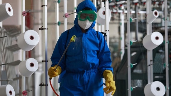 An employee of Songyo Knitwear Factory in Songyo district disinfects the work floor in Pyongyang, North Korea (AP Photo/Jon Chol Jin)(AP)