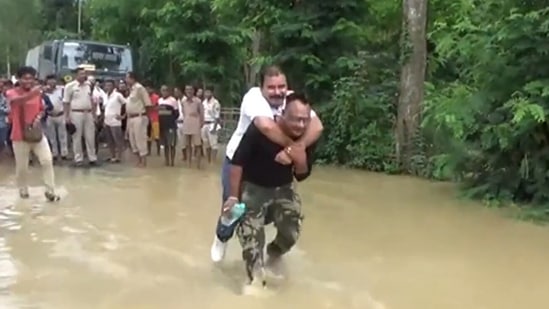 BJP MLA Sibu Misra gets piggyback ride from flood rescue worker in Assam's Hojai district. (Screengrab/ANI video)