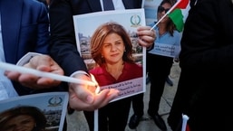 Pessoas acendem velas durante uma vigília em memória da jornalista da Al Jazeera, Shireen Abu Akleh, que foi morta durante um ataque israelense, do lado de fora da Igreja da Natividade em Belém, na Cisjordânia ocupada por Israel.