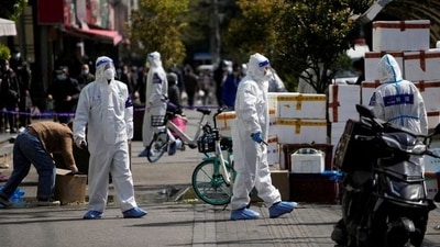 FILE PHOTO: Police and security members in protective suits stand outside cordoned off food stores following the COVID-19 outbreak in Shanghai, China. (REUTERS)