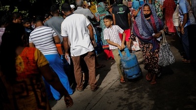A woman and her grandson carry an empty cylinder as they arrive to stand in a queue to buy domestic gas at a distribution centre, amid the country's economic crisis, in Colombo, Sri Lanka. (Reuters)