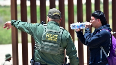 A US Border Patrol directs a migrant after he crossed into the US from Mexico through a gap in the border wall separating Algodones, Mexico, from Yuma. (AFP) A US Border Patrol directs a migrant after he crossed into the US from Mexico through a gap in the border wall separating Algodones, Mexico, from Yuma. (AFP)