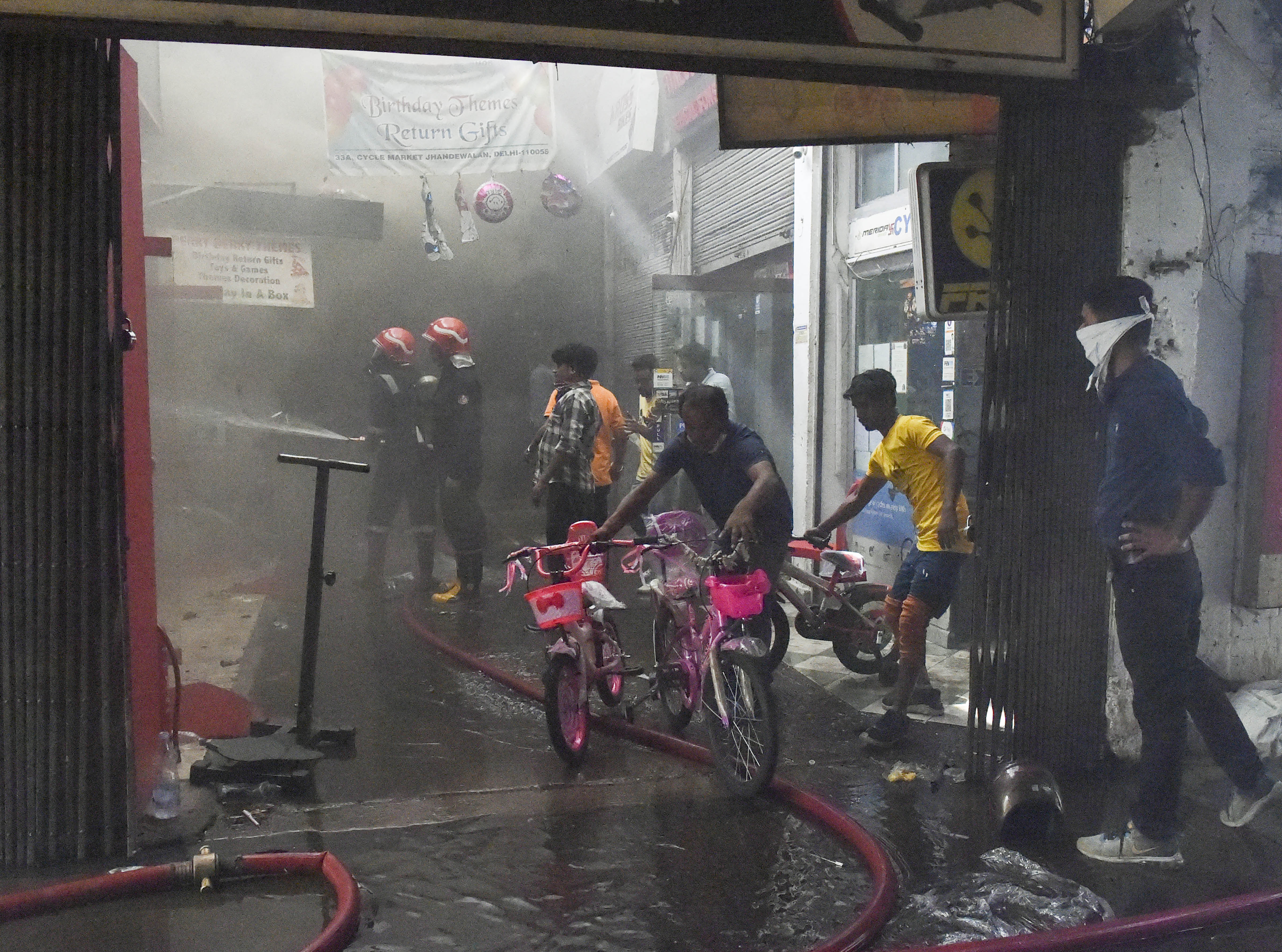 Firefighters attempt to douse a blaze in a godown at the Jhandewalan cycle market, in New Delhi, on Friday. (PTI) Firefighters attempt to douse a blaze in a godown at the Jhandewalan cycle market, in New Delhi, on Friday. (PTI)