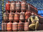 A worker sits inside a lorry, stacked with LPG cylinders . (PTI Photo)