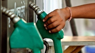 A worker lifts a petrol nozzle in New Delhi.&nbsp; (REUTERS file)