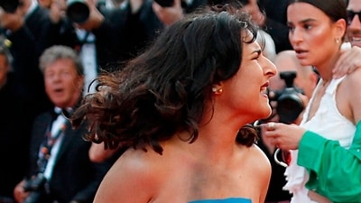 The 75th Cannes Film Festival - Screening of the film "Three Thousand Years of Longing" Out of Competition - Red Carpet Arrivals - Cannes, France, May 20, 2022. A woman reacts on the red carpet while protesting. (REUTERS)