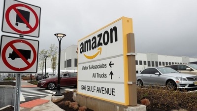 An Amazon sign stands in a parking lot outside of an Amazon warehouse in New York, US. (REUTERS)
