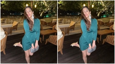 Disha's ensemble comes in an emerald green shade. It features a mini hem length, plunging V neckline with a wrapover detail, full sleeves and a bodycon silhouette accentuating the actor's curves aesthetically. The actor paired the dress with white embroidered statement earrings, a silver embellished clutch and white sandals. (Instagram/@dishaparmar) Disha's ensemble comes in an emerald green shade. It features a mini hem length, plunging V neckline with a wrapover detail, full sleeves and a bodycon silhouette accentuating the actor's curves aesthetically. The actor paired the dress with white embroidered statement earrings, a silver embellished clutch and white sandals. (Instagram/@dishaparmar)