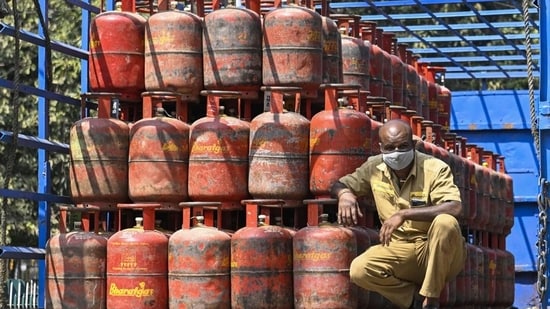 A worker sits inside a lorry, stacked with LPG cylinders . (PTI Photo)