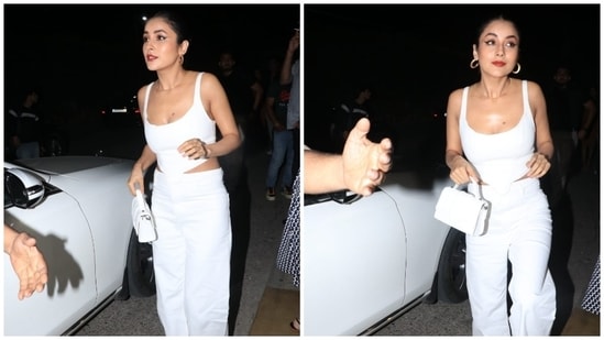 Shehnaz paired the corset top with a pair of high-waisted trousers in matching white.  It features a flared hem and a silhouette mounted on top.  The actor paired the entire white look with a tan peep-toe high heels and textured top handle mini bag. (HT Photo / Warinder Chawla)