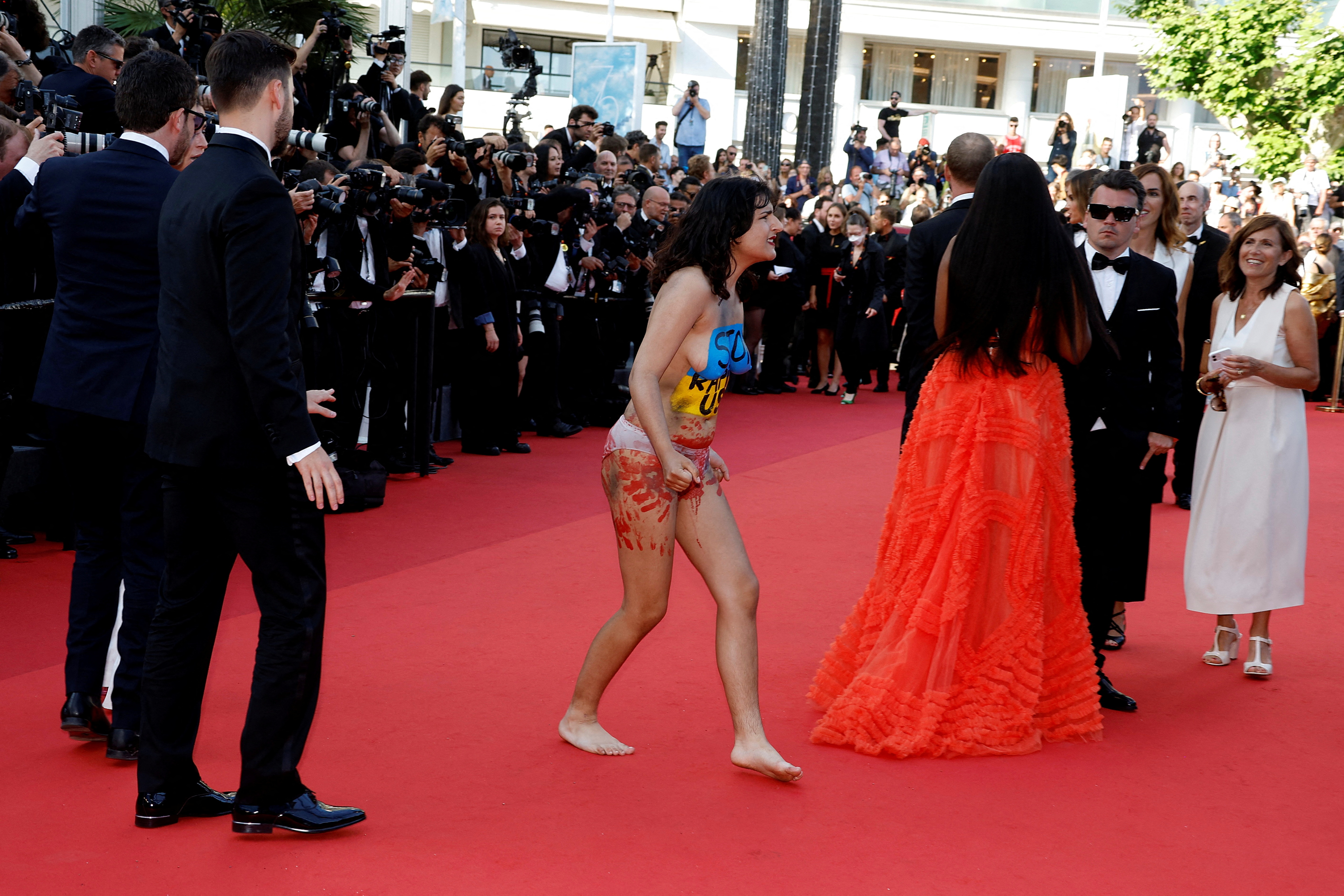 The 75th Cannes Film Festival - Screening of the film "Three Thousand Years of Longing" Out of Competition - Red Carpet Arrivals - Cannes, France, May 20, 2022. A woman with her bare chest painted in the colors of the Ukrainian flag protests. Writing on her chest reads: "Stop raping us". REUTERS/Eric Gaillard(REUTERS)