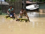 Children ride a bamboo raft through a flooded area after heavy rainfall in Morigaon district of Assam state on Sunday.(AFP) Children ride a bamboo raft through a flooded area after heavy rainfall in Morigaon district of Assam state on Sunday.(AFP)
