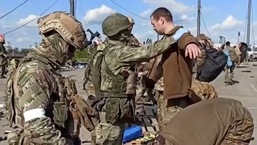 Nesta foto tirada de um vídeo divulgado pelo Ministério da Defesa russo em 20 de maio de 2022, militares russos revistam militares ucranianos depois que eles deixaram a usina de aço Azovstal sitiada em Mariupol. 