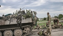 TOPSHOT - Militares ucranianos ajudam seus camaradas não muito longe da linha de frente na região leste ucraniana de Donbas, em 21 de maio de 2022. (Foto da AFP)