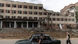 A local resident walks by a destroyed building after a rocket attack on a university campus, amid Russia's invasion, in Bakhmut, in the Donetsk region, Ukraine.