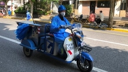 Um trabalhador usando uma máscara facial e um avental de proteção dirige um carrinho por uma rua em Xangai, na China, no sábado. 