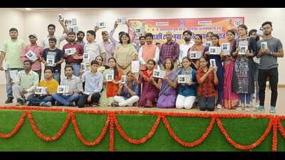 Students pose with their newly acquired smart phones and tablets alongside UP cabinet minister Nand Gopal Gupta and UPRTOU V-C Prof Seema Singh on Sunday. (HT Photo)