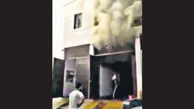Smoke billowing out of the godown of the hosiery unit on Bahadur Road where the fire broke out on Sunday. Fire fighters managed to keep the flames contained to the ground floor. (HT Photo)