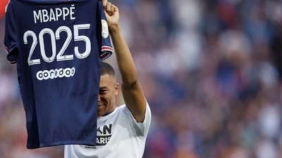 Paris St Germain's Kylian Mbappe holds up a shirt after signing a new contract (REUTERS)