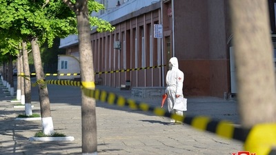 In this photo provided by the North Korean government, a worker in protective gear stands on an empty sidewalk in Pyongyang. (Korean Central News Agency/Korea News Service via AP)